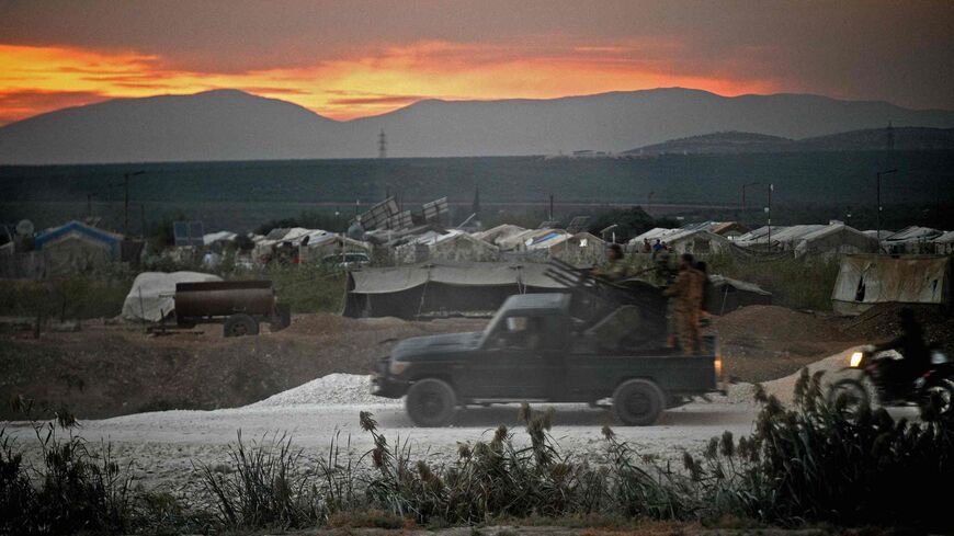 Members of the Hayat Tahrir al-Sham (HTS) jihadi group advance toward the village of Jindayris.