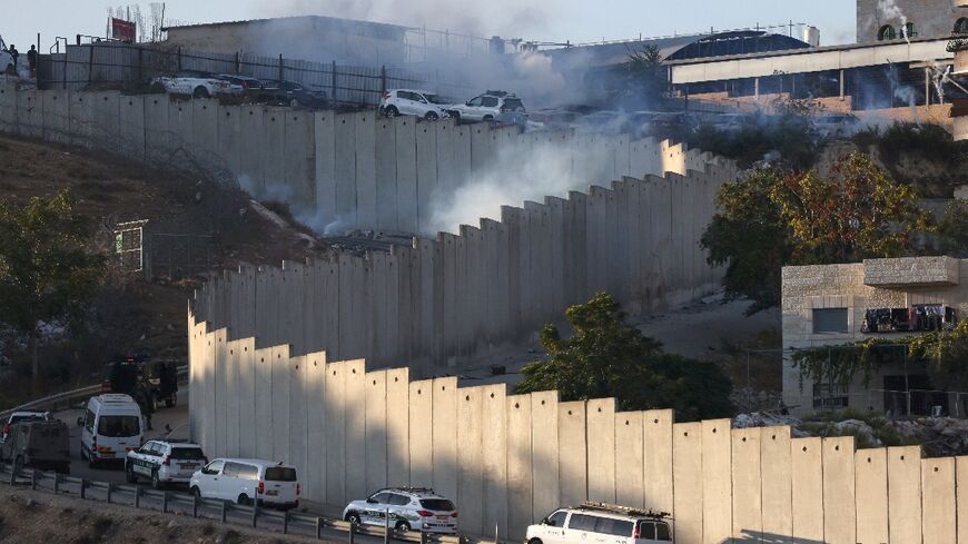 Smoke billows as Israeli security forces conduct a manhunt following a shooting attack, in the Palestinian Shuafat refugee camp by the separation barrier in Israeli-annexed east Jerusalem