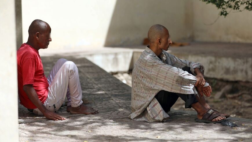 Patients at a psychiatric hospital sit outdoors in the shade in Yemen's third city of Taez