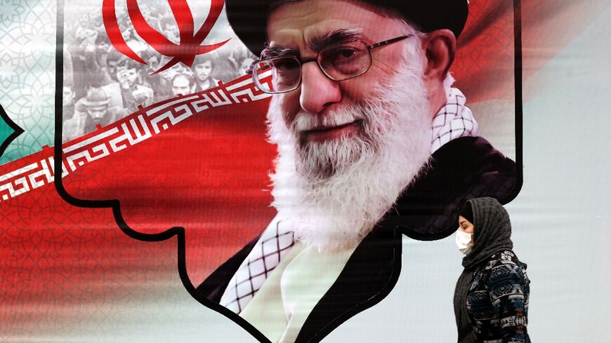 An Iranian woman walks past a billboard showing the supreme leader Ayatollah Ali Khamenei in the capital Tehran