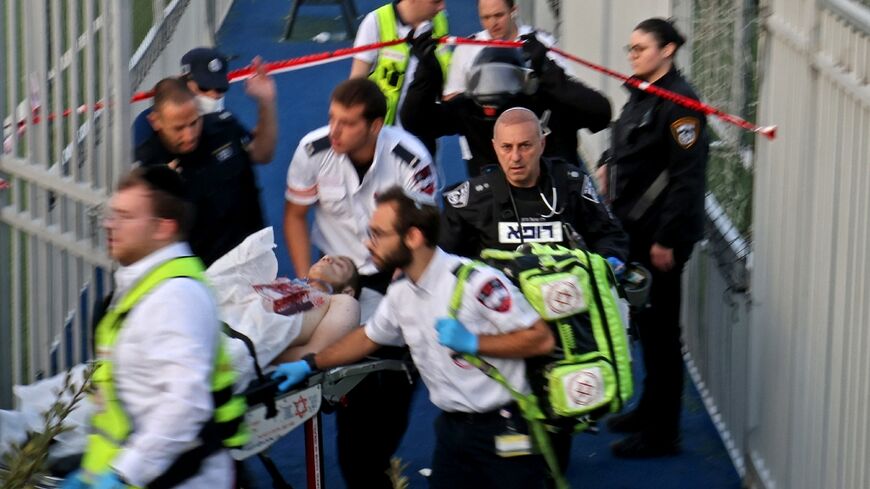 Israeli security forces and emergency personnel carry away a Palestinian man, shot after a stabbing attack in east Jerusalem