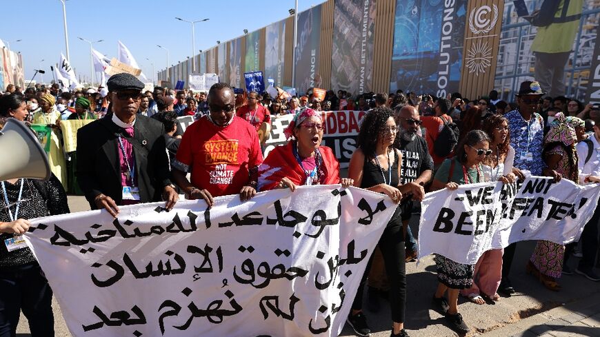 The sister of jailed Egyptian activist Alaa Abdel Fattah, Sanaa Seif (fourth from left), was at the front of the protest for climate justice and human rights