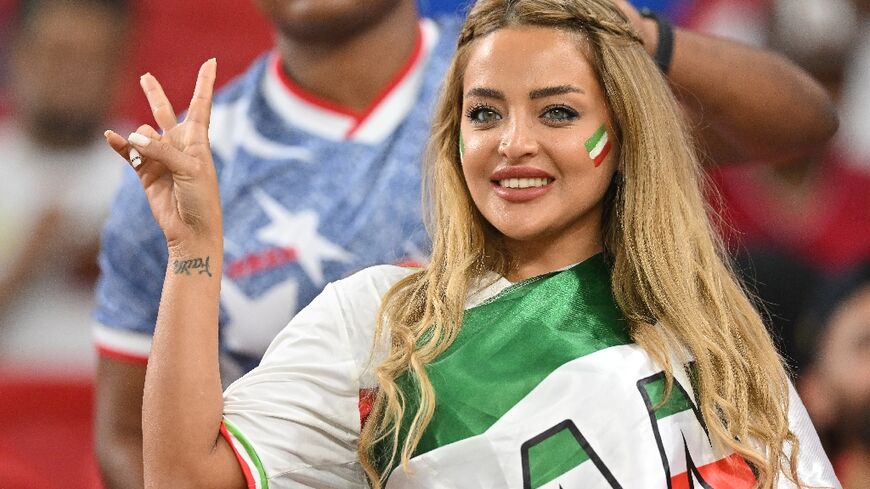 An Iran supporter, draped and painted in the national colours, cheers on her team against the US on Tuesday night