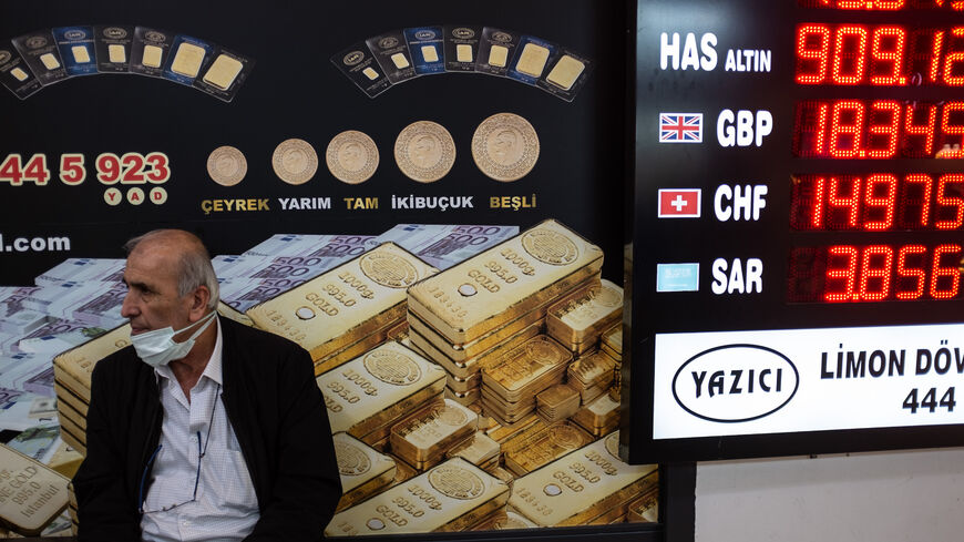 A man sits next to a currency exchange office at Istanbul's Grand Bazaar on May 5, 2022.