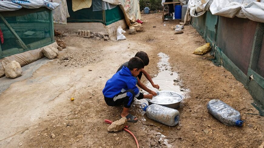 Amid an outbreak of cholera in the region, children rinse their hands at a camp for Syrian refugees in Talhayat, Lebanon