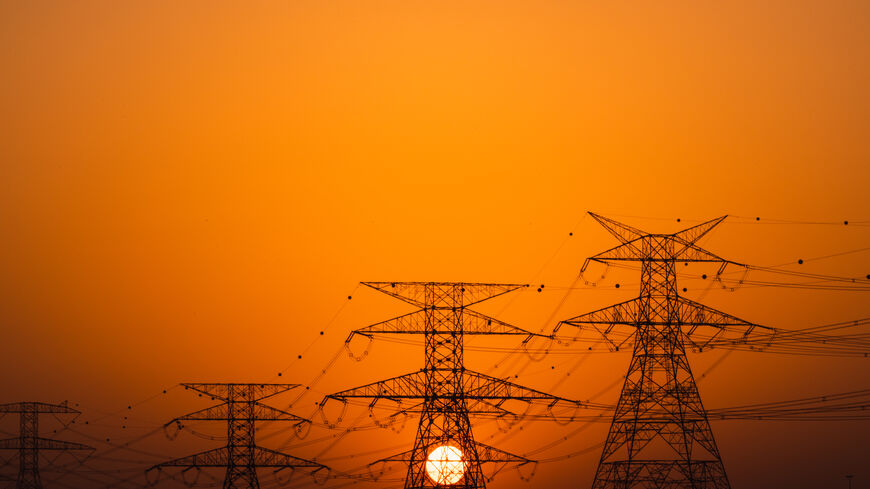 Sunset shot showing a row of electricity pylons in the desert, Dubai, United Arab Emirates (Getty Images)