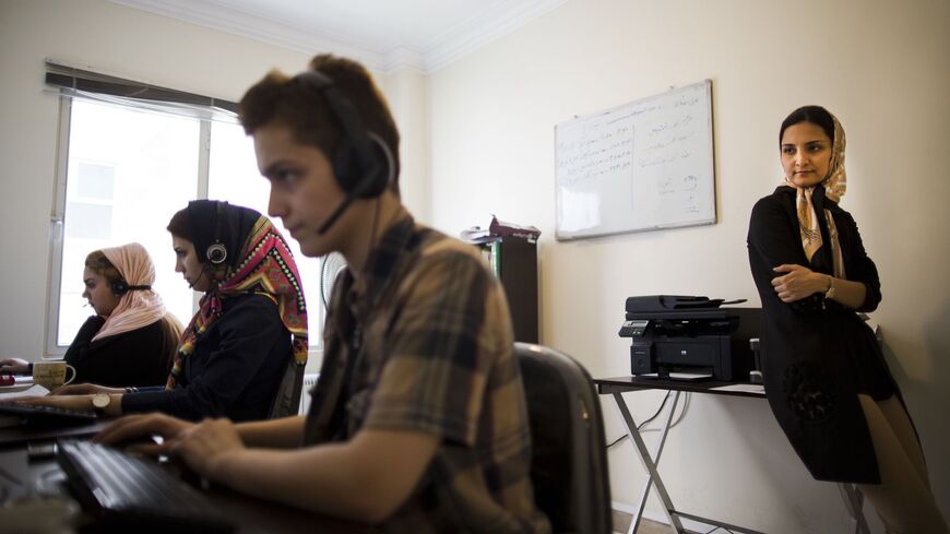 Iranian Nazanin Daneshvar (R) founder of Takhfifan startup company watches her employees working at the desk in Tehran on July 1, 2015. Women are more likely to start businesses. Very present in senior positions of the Islamic Republic, they are needed in the private sector. AFP PHOTO/BEHROUZ MEHRI / AFP / BEHROUZ MEHRI (Photo credit should read BEHROUZ MEHRI/AFP via Getty Images)