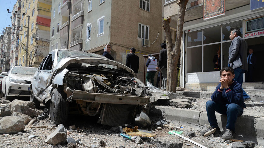 People gather near the site of an explosion that hit the police headquarters the day before in the Kurdish majority city of Diyarbakir, southeastern Turkey, April 12, 2017.