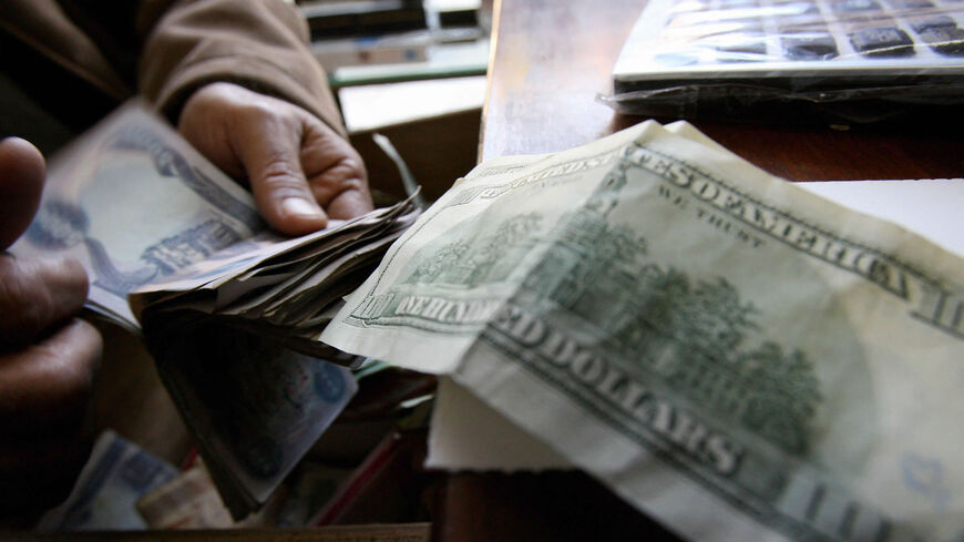 An Iraqi man counts Iraqi dinars as he exchanges them for US dollars at a money exchange office, Baghdad, Iraq,  Dec. 12 2007. 