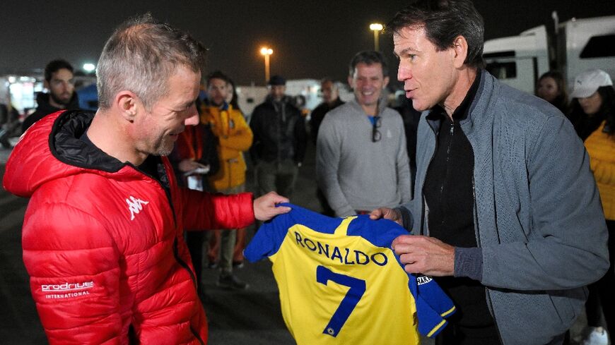 Al-Nassr coach Rudi Garcia (right) presents fellow Frenchman and star driver Sebastien Loeb with a Cristiano Ronaldo club shirt at the Dakar Rally bivouac in Riyadh