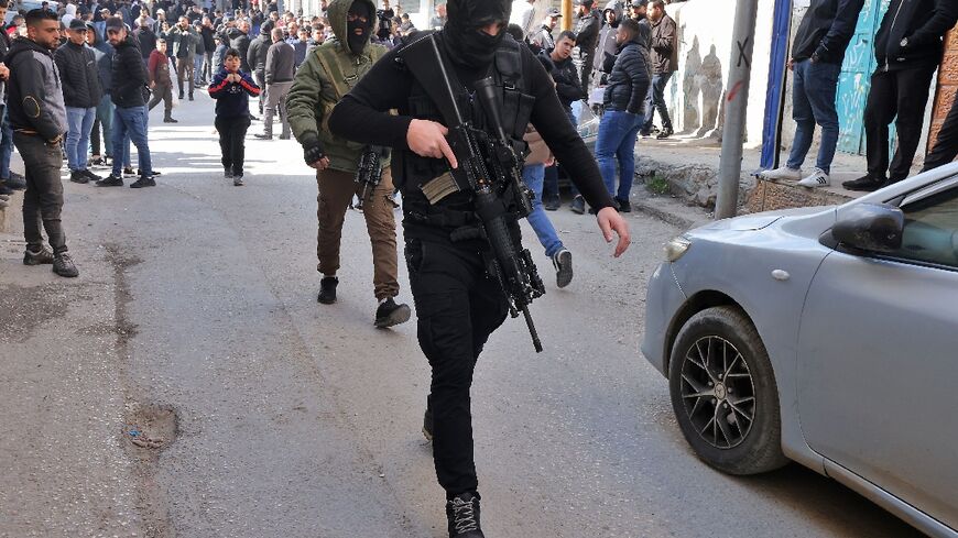 A Palestinian gunman attends the funeral of Samir Aslan, 41, at Qalandia refugee camp in the occupied West Bank, on January 12, 2023