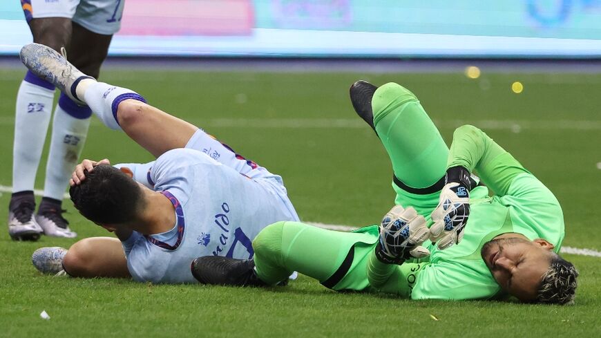 Fallen stars: Cristiano Ronaldo and PSG goalkeeper Keylor Navas feel the pain after clashing on Thursday