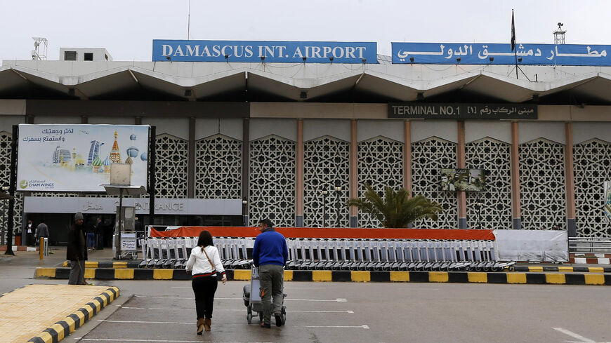 Travelers head to an entrance of Damascus International Airport, Damascus, Syria, Feb. 19, 2020.