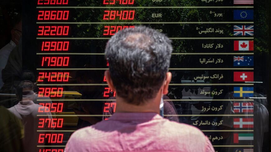 An Iranian man looks looks at currency exchange rates outside a shop in downtown Tehran on June 15, 2021. - Iran holds a presidential election on June 18, with ultraconservative Ebrahim Raisi, who heads the judiciary, most likely to win from the seven candidates. (Photo by MORTEZA NIKOUBAZL / AFP) (Photo by MORTEZA NIKOUBAZL/AFP via Getty Images)