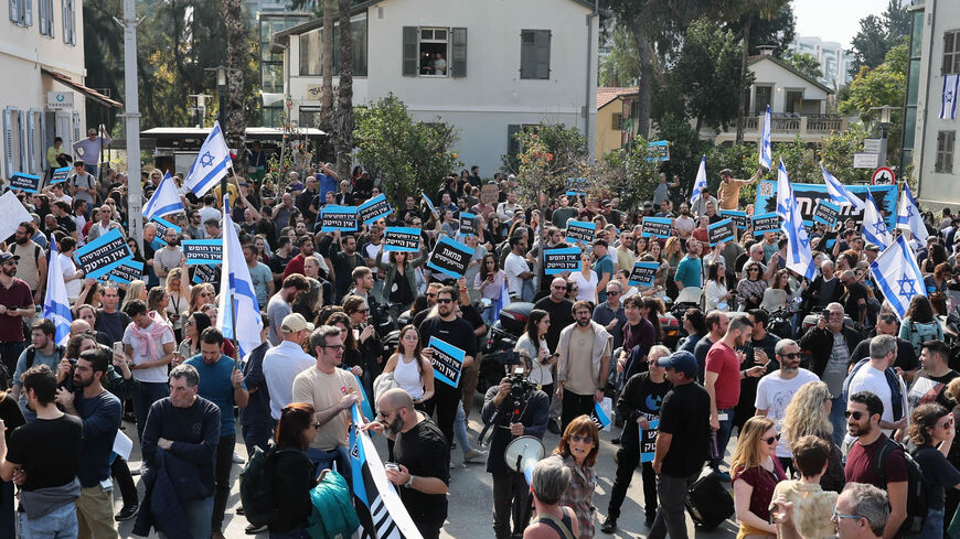 High-tech company workers block a road and hold signs as they strike for an hour to protest the Israeli government's controversial plans to overhaul the judicial system, Tel Aviv, Israel, Jan. 24, 2023.