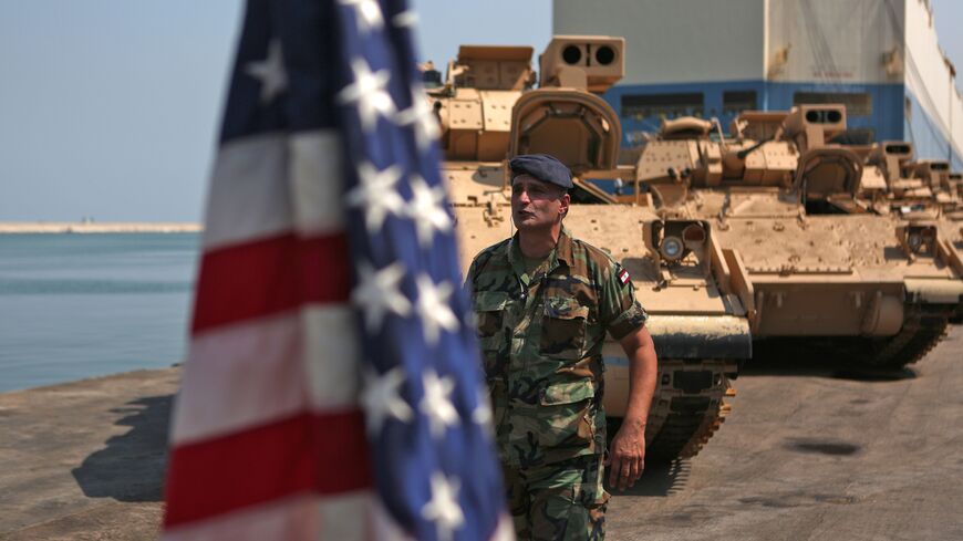 A Lebanese soldier walks past an American flag flying next to US made Bradley Fighting Vehicles at the port of Beirut on August 14, 2017. (Photo credit should read PATRICK BAZ/AFP via Getty Images)