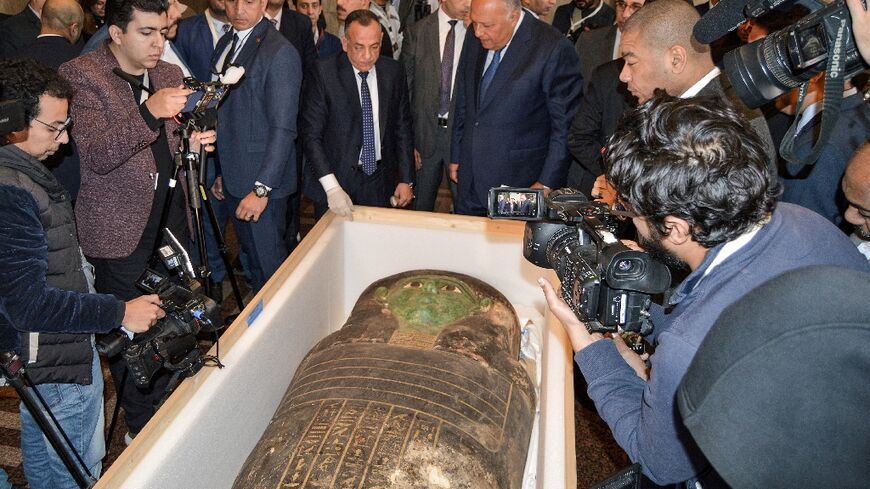 Egypt's Foreign Minister Sameh Shoukry (C-R) and the head of the Supreme Council of Antiquities Mostafa Waziri (C-L) inspect the "Green Sarcophagus"