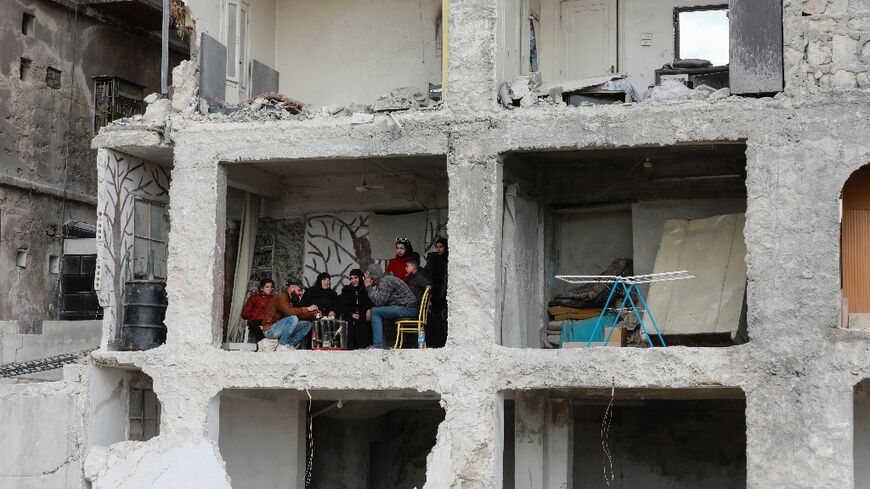 Ali al-Bash and his mother Amina Raslan drink coffee at home, in a building damaged by the 7.8-magnitude quake, in Aleppo city's al-Masharqa neighbourhood