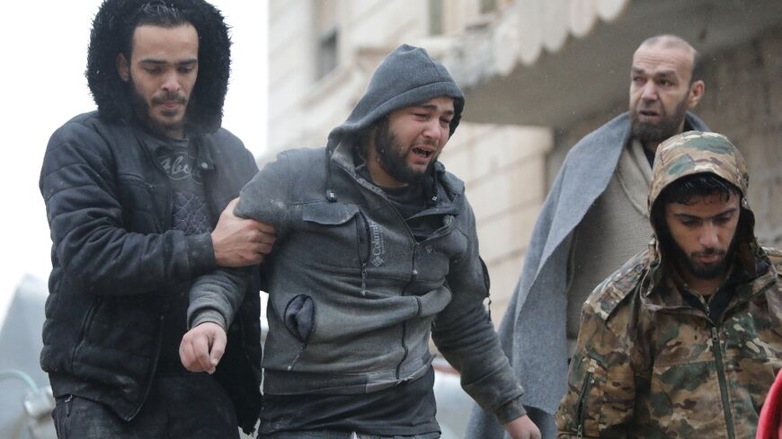 A Syrian man weeps following the death of his infant son an earthquake in the town of Jandairis, in the countryside of Syria's northwestern city of Afrin in the rebel-held part of Aleppo province