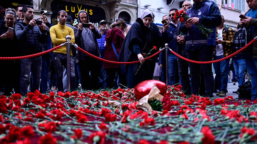 People lay flowers at a makeshift memorial for the victims of the Nov. 13 explosion at the busy shopping street of Istiklal, Istanbul, Turkey, Nov. 14, 2022.