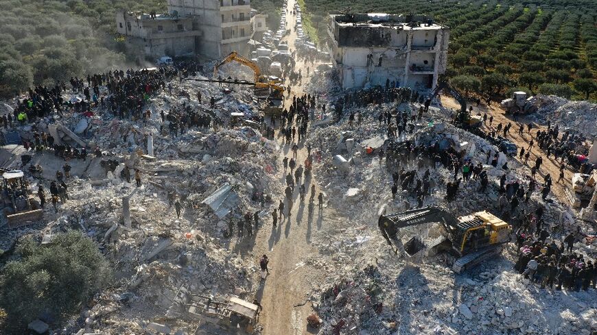 An aerial view of rescuers searching the rubble in the village of Besnaya in northwest Syria