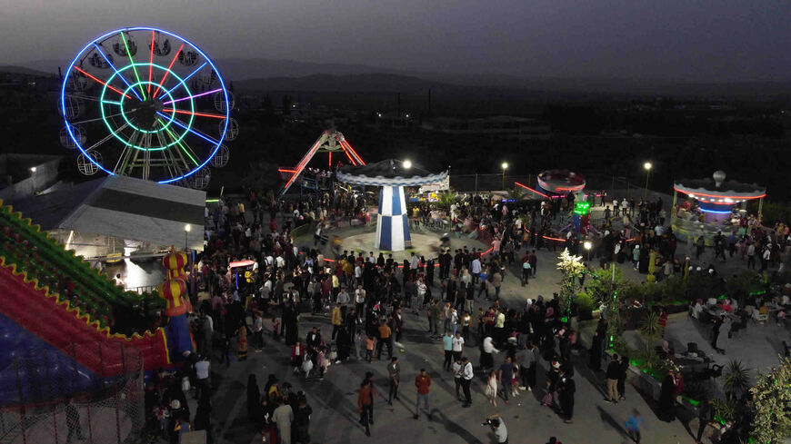 Displaced families celebrate with their children the Eid al-Fitr Muslim holiday, which marks the end of the fasting month of Ramadan, at a luna park in Afrin, Aleppo province, Syria, May 3, 2022.