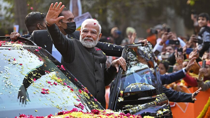 India's Prime Minister Narendra Modi (C) waves to his supporters during a roadshow ahead of the BJP national executive meet in New Delhi on January 16, 2023. (Photo by SAJJAD HUSSAIN/AFP via Getty Images)