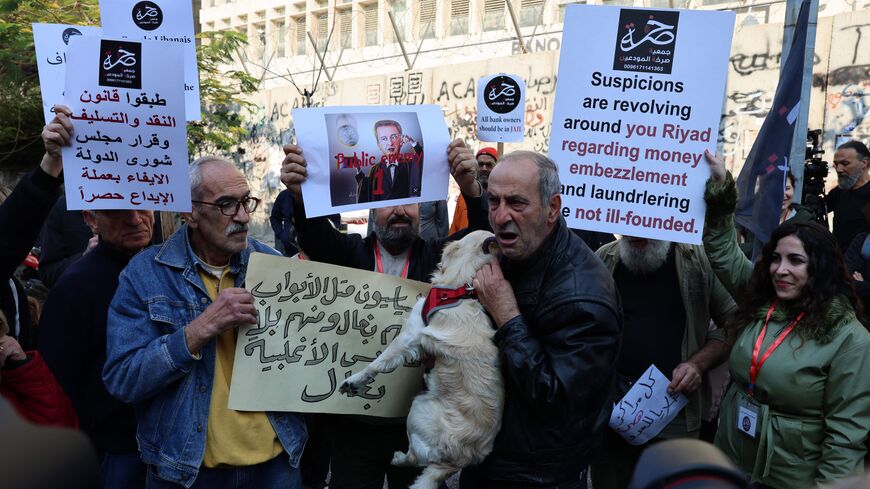 Lebanese protesters demonstrate against the monetary policies of Lebanon's Central Bank governor in the capital Beirut on January 25, 2023. - European investigators will question Lebanon's central bank chief Riad Salameh (portraits) next month as part of a probe into his and his brother's affairs, a judicial official told AFP earlier this week. Investigators from France, Germany and Luxembourg heard witnesses in Beirut last week as part of the case of suspected financial misconduct including possible money