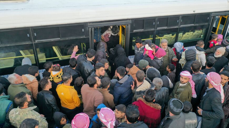 An aerial picture shows Syrian refugees living in Turkey waiting to take a bus through the northern Bab al-Hawa border crossing, on February 17, 2023, as they return to Syria in the aftermath of a deadly earthquake. - Turkey this week allowed Syrians under its protection who hold ID cards from one of the quake-hit provinces to leave for between three and six months, a rule change designed to reunite families on both sides of the border hit by the February 6 disaster, which has killed more than 41,000 people