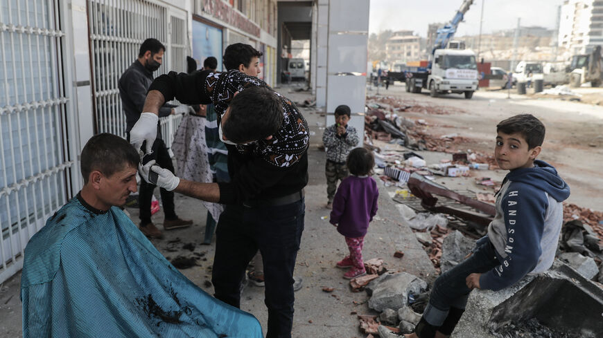 Hairdressers give haircuts to people displaced by the earthquake at tent camp on February 19, 2023 in Hatay, Turkey. A 7.8-magnitude earthquake hit near Gaziantep, Turkey, in the early hours of February 6, followed by another 7.5-magnitude tremor just after midday. The quakes caused widespread destruction in southern Turkey and northern Syria and has killed more than 40,000 people. (Photo by Burak Kara/Getty Images)