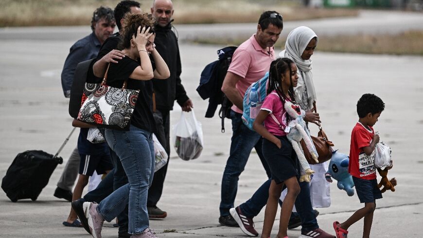 Greek nationals from Sudan arrive with a military C-27 plane at the military airport of Elefsina, south of Athens, on April 25, 2023