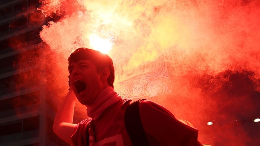 A protester brandishes a flare during protests in Tel Aviv against the government's judicial reform bill