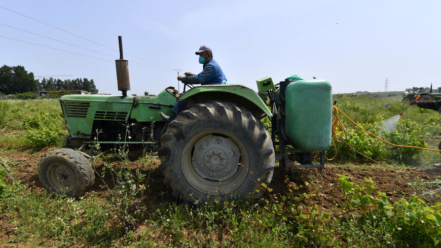 Farmers spray grapevines at a vineyard in Souidania town, 15 Km west of the Algerian capital, on May 16, 2022. (Photo by RYAD KRAMDI / AFP) (Photo by RYAD KRAMDI/AFP via Getty Images)