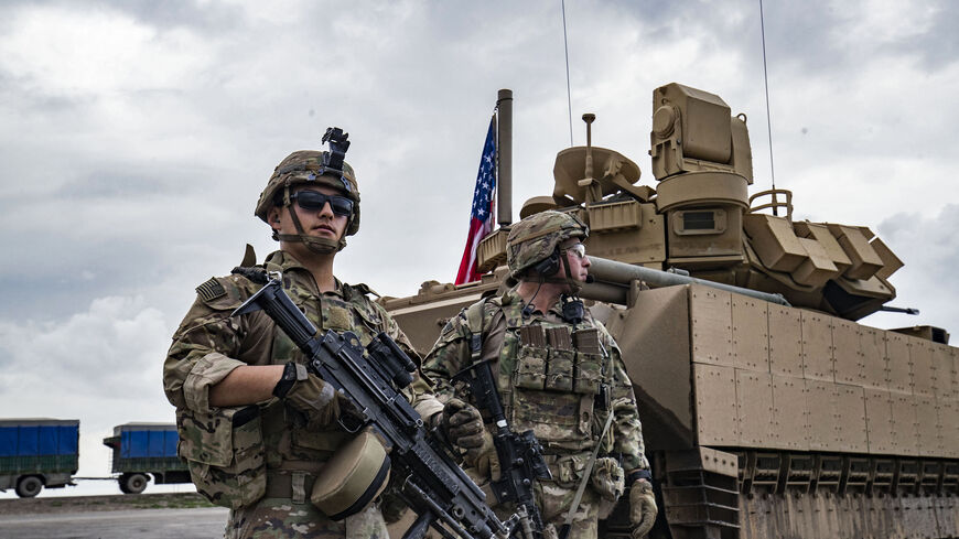 US army soldiers stand near an armoured military vehicle on the outskirts of Rumaylan in Syria's northeastern Hasakeh province, bordering Turkey, on March 27, 2023. (Photo by Delil souleiman / AFP) (Photo by DELIL SOULEIMAN/AFP via Getty Images)