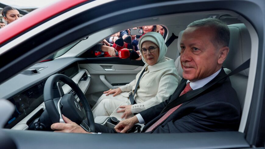 Turkey's President Recep Tayyip Erdogan (R) and his wife Emine Erdogan (L) sit in their Togg T10X, Turkey's first domestically-produced electric car, after receiving it from the company at the Presidential Complex in Ankara, on April 3, 2023. (Photo by Adem ALTAN / AFP) (Photo by ADEM ALTAN/AFP via Getty Images)