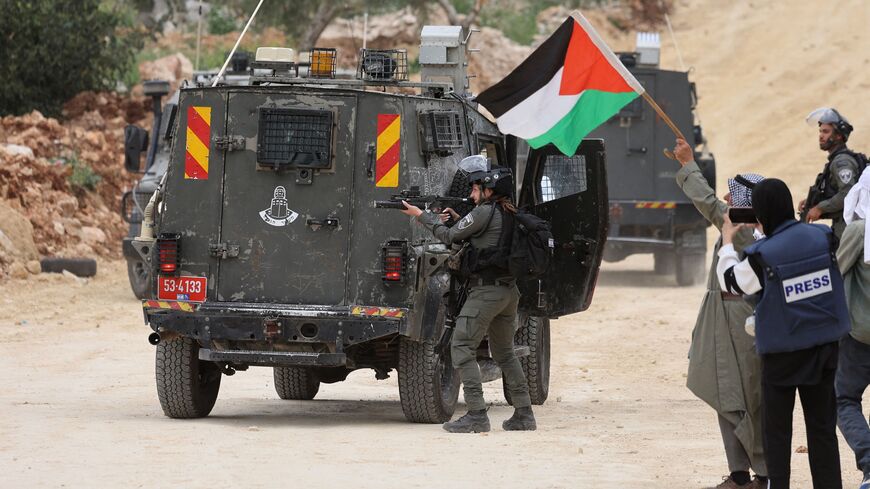 An Israeli soldier takes aim during a protest by Palestinians in the village of Beita, south of Nablus in the occupied West Bank, on April 10, 2023, against a march by settlers to the nearby Israeli outpost of Eviatar. (Photo by JAAFAR ASHTIYEH / AFP) (Photo by JAAFAR ASHTIYEH/AFP via Getty Images)