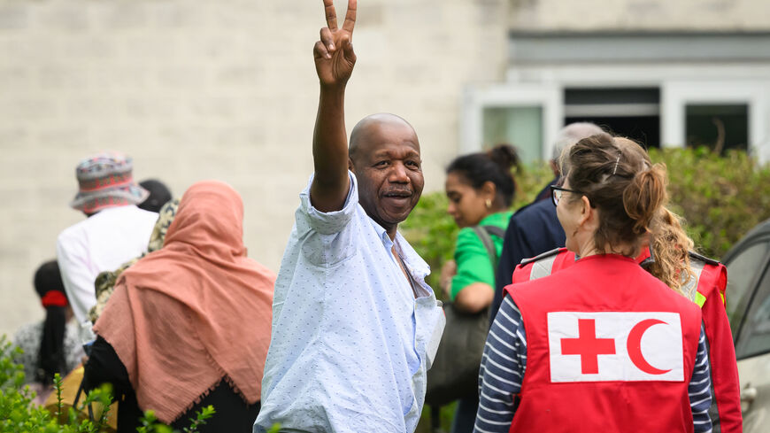 A man gestures towards the media as people arrive at Stansted Airport from Sudan on April 27, 2023 in Stansted, Essex. The British government has coordinated a series of evacuation flights of British nationals from Khartoum, during a short ceasefire between rival military factions. (Photo by Leon Neal/Getty Images)