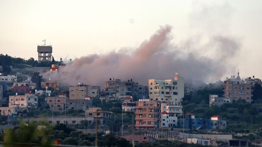 Smoke billows over the West Bank village of Hares as Israeli troops demolish the home of a Palestinian accused of killing three Israelis in a car-ramming and stabbing attack last year