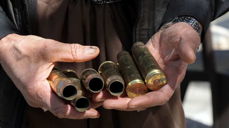 Moustafa Ahmed shows bullet casings collected after one of the many firefights near his home