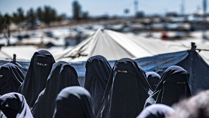 Women queue to receive humanitarian aid packages at the Kurdish-run al-Hol camp, which holds relatives of suspected Islamic State (IS) group fighters, in Syria's northeastern Hasakeh governorate on August 18, 2021. (Photo by Delil SOULEIMAN / AFP) (Photo by DELIL SOULEIMAN/AFP via Getty Images)