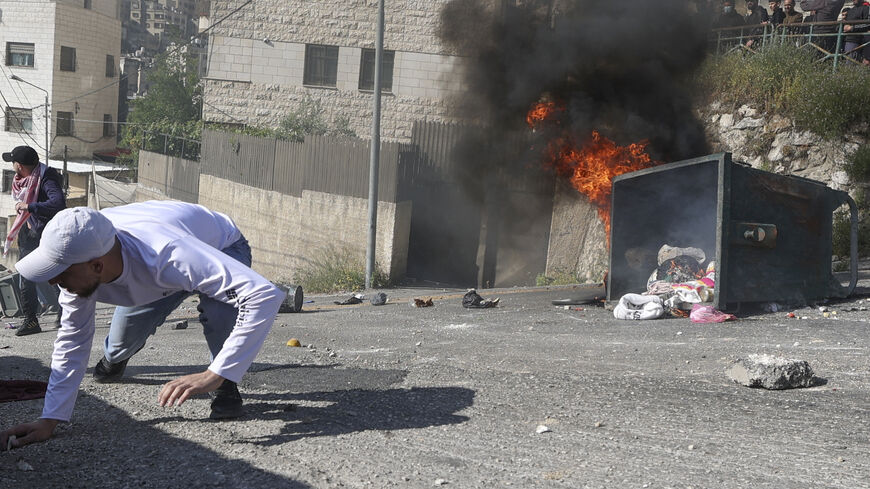 Palestinian protesters take cover amid clashes with Israeli security forces during a raid in the old city of Nablus, in the occupied West Bank, on May 9, 2023. - The Israeli army said it killed three leaders of the Islamic Jihad militant group on May 9 in air strikes on Gaza, which left a dozen dead according to the Palestinian territory's Hamas-controlled health ministry, adding that women and children were among the dead. (Photo by Jaafar ASHTIYEH / AFP) (Photo by JAAFAR ASHTIYEH/AFP via Getty Images)