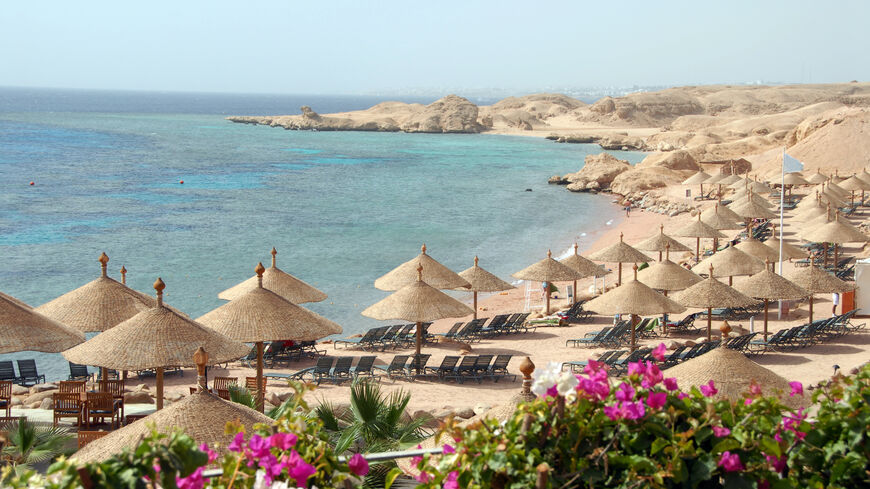 Beach with parasols and blooming bougainvillea near Sharm el-Sheikh,Red Sea,Egypt.