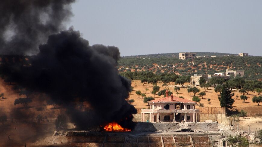 A plume of smoke rises from a building following reported Russian air strikes on Syria's northwestern rebel-held Idlib province