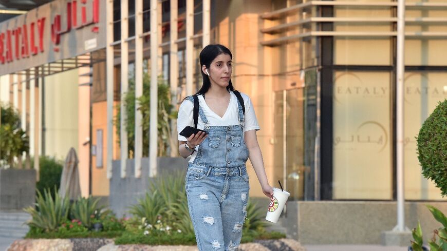 Saudi Arabian woman Manahel al-Otaibi walks on a Riyadh street in  2019 without the customary body-shrouding abaya