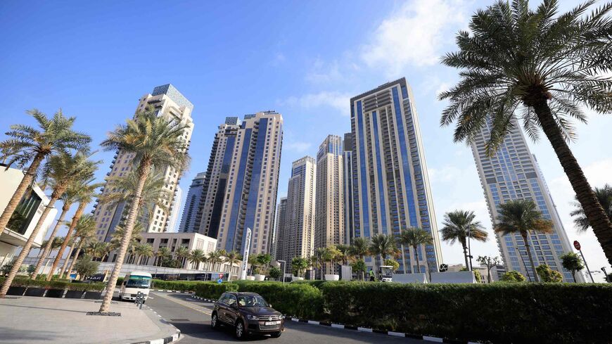 Cars drive along a street in front of high-rise buildings in Dubai on Feb. 18, 2023.