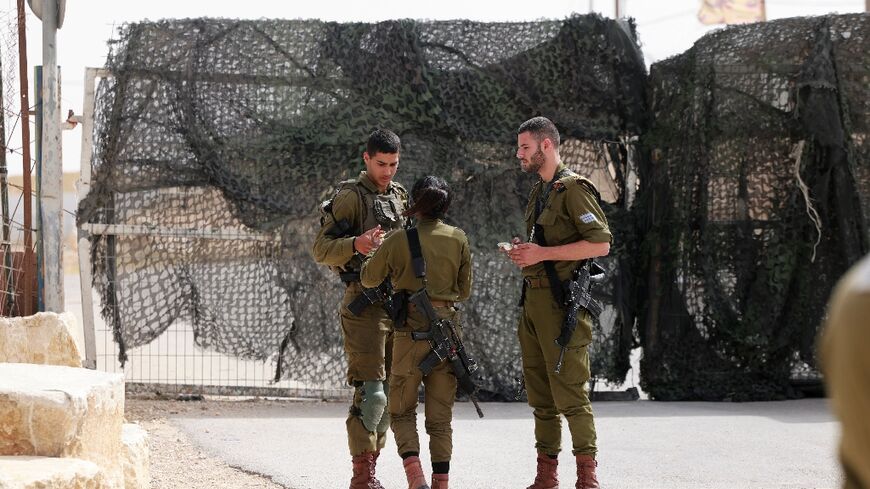 Israeli soldiers are pictured at the gate of the Mount Harif military base near the city of Mitzpe Ramon in Israel's southern Negev desert, adjacent to the border with Egypt