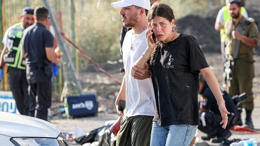 A man and a woman walk at the scene of a deadly attack near the Jewish settlement of Eli in the north of the occupied West Bank