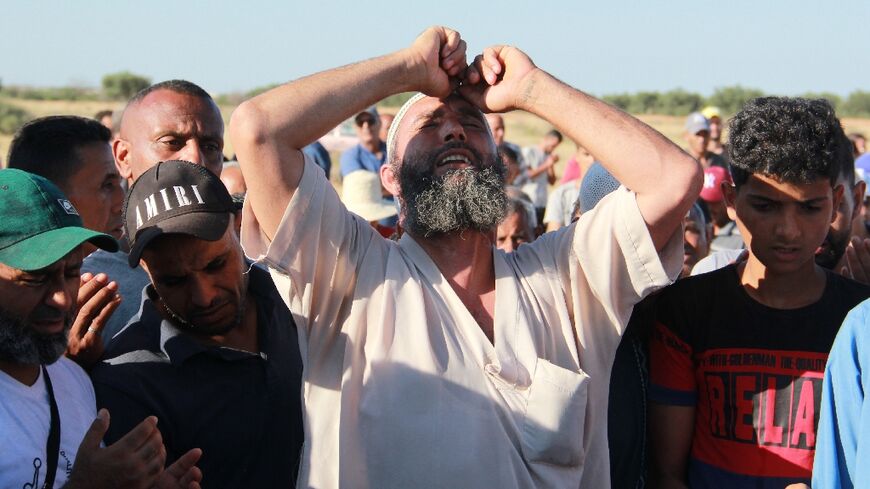 Tunisians mourn during the funeral of a man who was fatally stabbed during a scuffle between local residents and migrants from sub-Saharan Africa, in Sfax