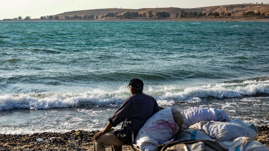 Ismail Hilal' who retired after 37 years as a fisherman, sits on a boat on the banks of Lake Assad 