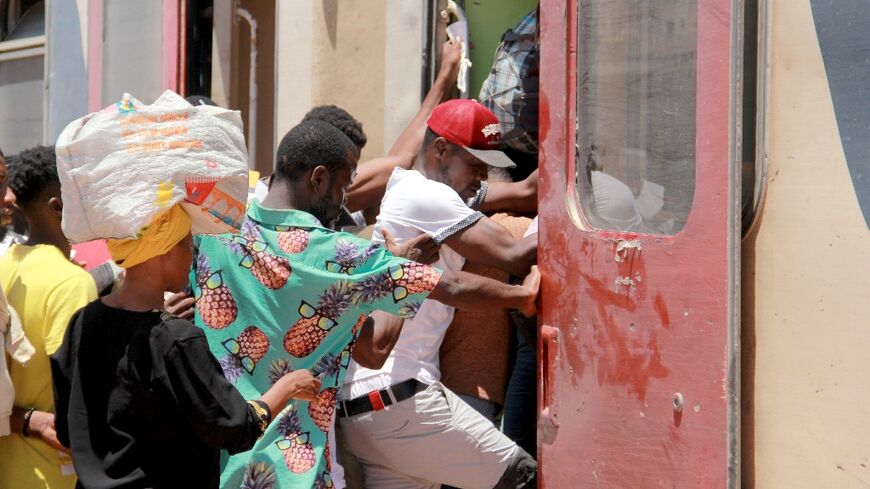 Migrants board a train as they flee amid unrest in the Tunisian city of Sfax